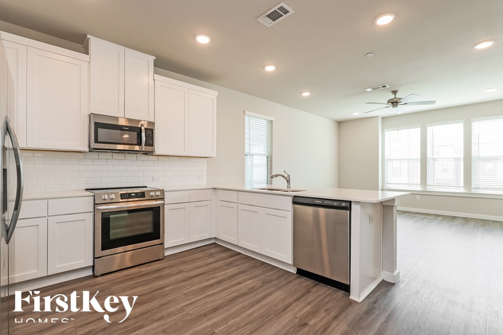A kitchen with white cabinets and a stainless steel dishwasher.