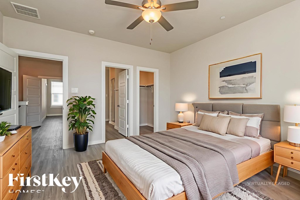 A bedroom with a large bed and a ceiling fan.