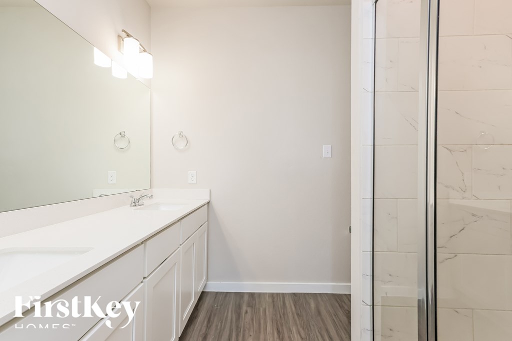 A bathroom with a white sink and a mirror.