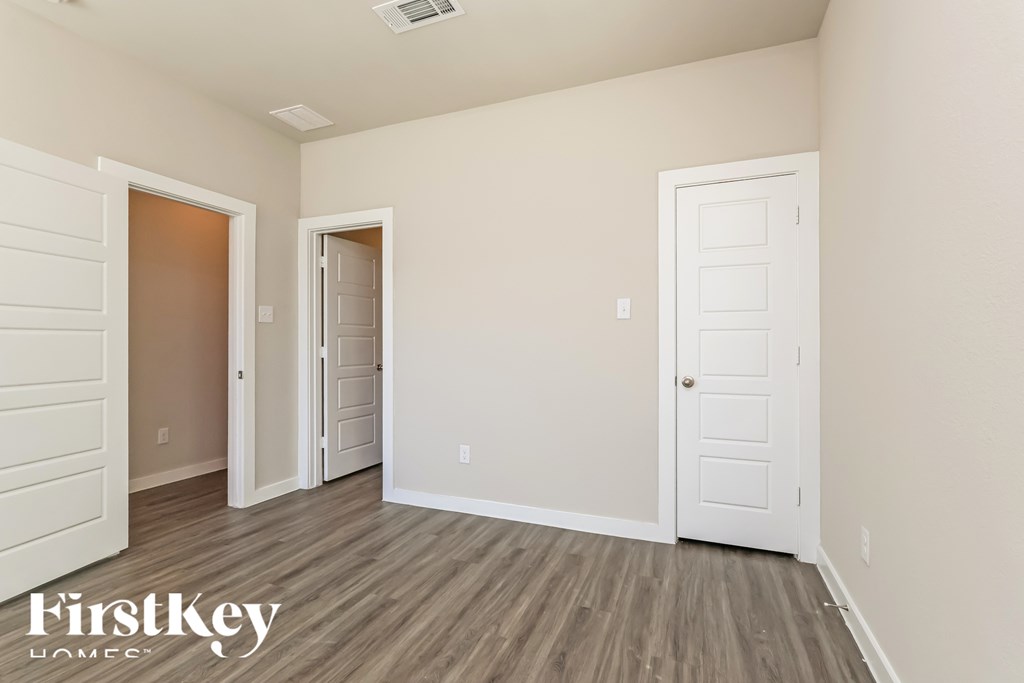 A room with a white door and a wooden floor.