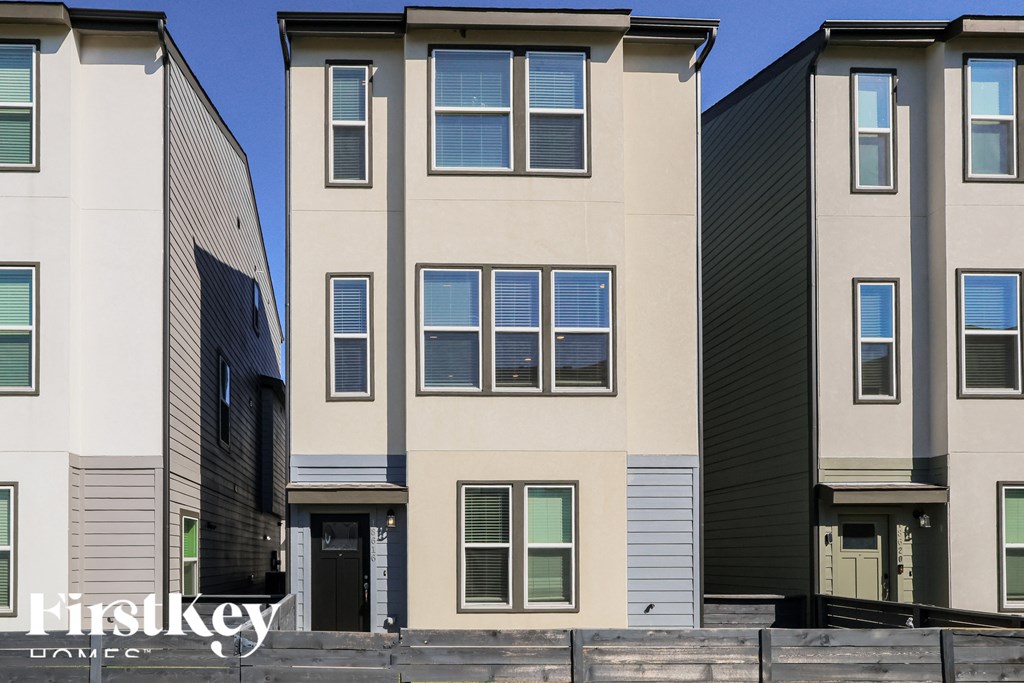 A row of modern townhouses with different shades of beige and grey.