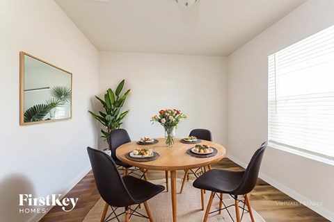 A dining room with a wooden table and chairs.