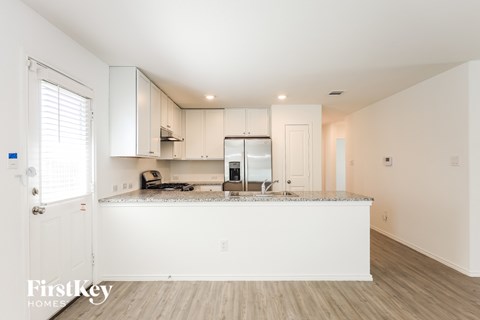 A kitchen with a white counter top and cabinets.