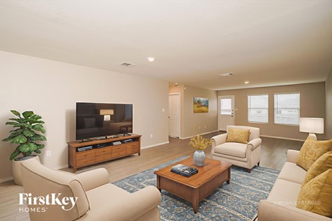 A living room with a flat screen TV and a coffee table.