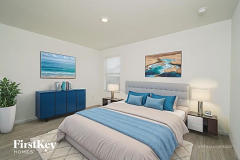 A bedroom with a bed, nightstands, and two paintings on the wall.