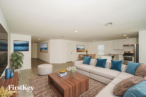 A modern living room with a white sofa and a wooden coffee table.
