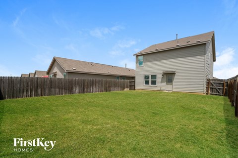 A house with a fence and a grassy yard.