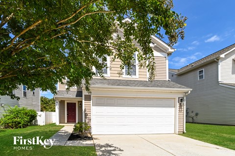 A house with a brown roof and a white garage door is for sale.