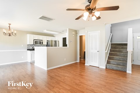 A spacious living room with a staircase leading to the upper floor.