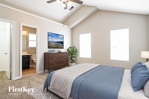 A bedroom with a bed, dresser, and ceiling fan.