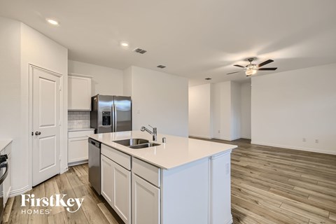 A kitchen with white cabinets and a stainless steel refrigerator.
