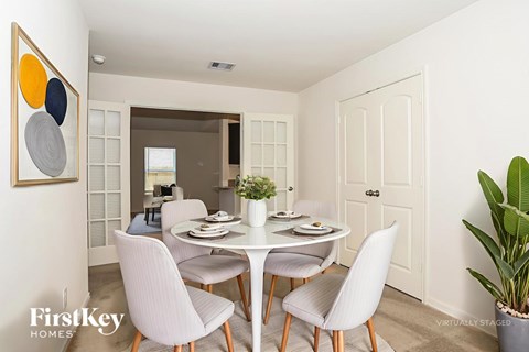 A dining room with a white table and chairs.