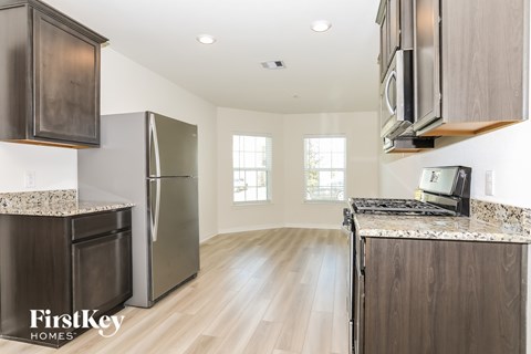 A kitchen with wooden cabinets and a granite countertop.