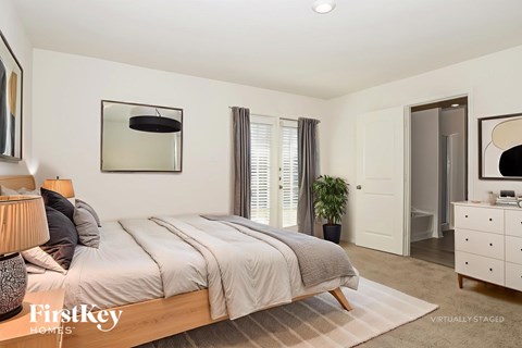 A bedroom with a large bed, a dresser, and a mirror.