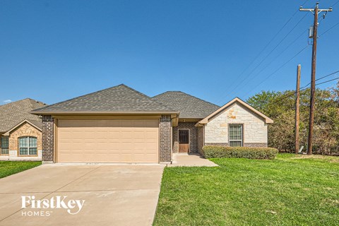 A house with a garage and a driveway in front of it.