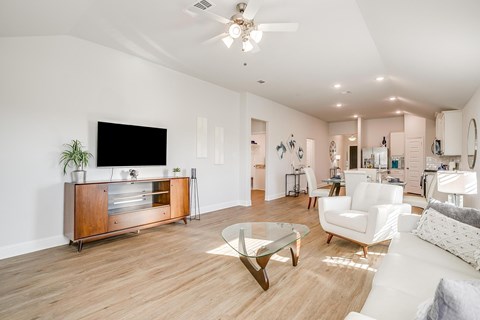 A modern living room with a wooden floor and white walls.