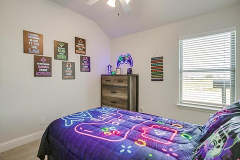 A room with a bed and a dresser with a neon sign on top.
