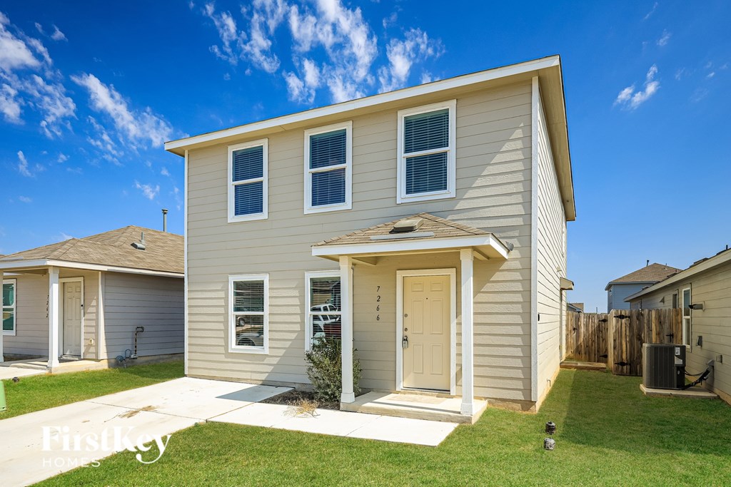 A beige house with a white door and windows is shown.