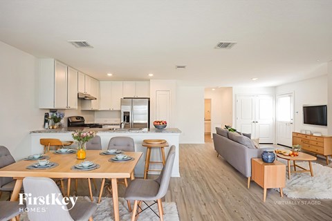 A modern kitchen with a dining table set for six.