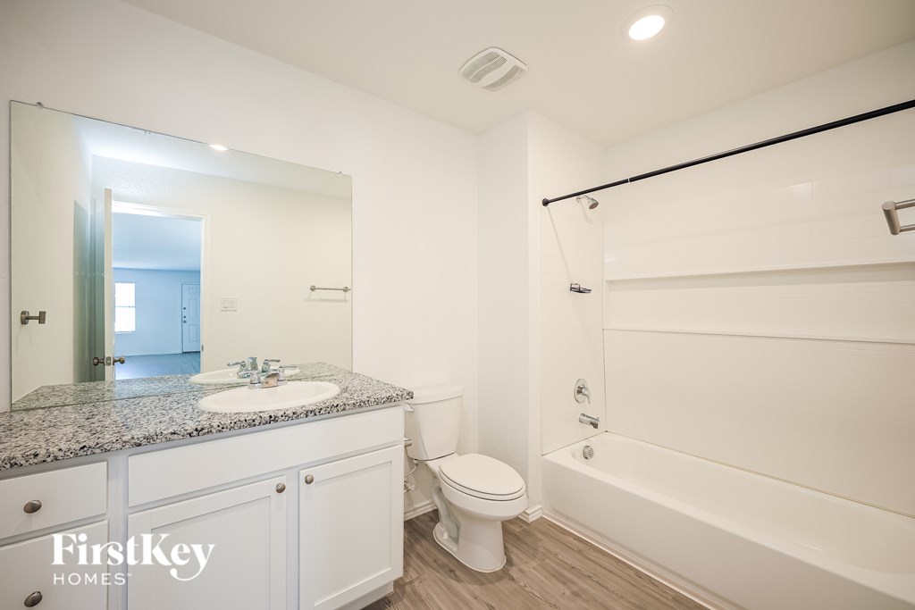 A bathroom with a white toilet, sink, and bathtub.