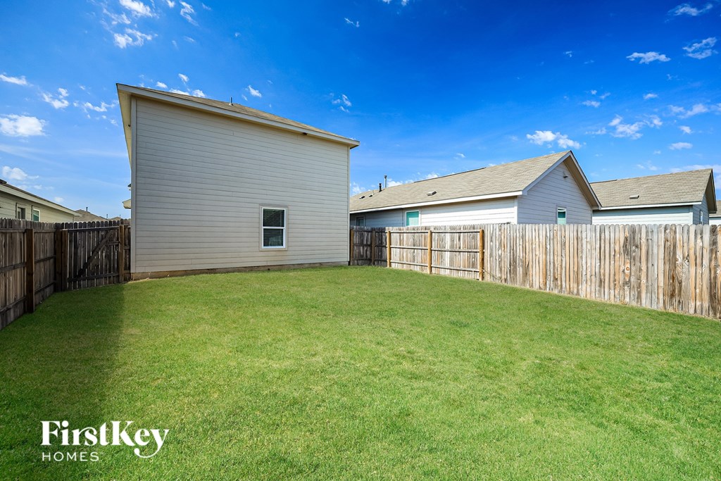 A backyard with a shed and a fence.