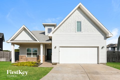 A white house with a garage is for sale.