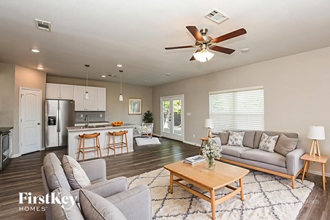 A well-lit living room with a grey sofa and a wooden coffee table.