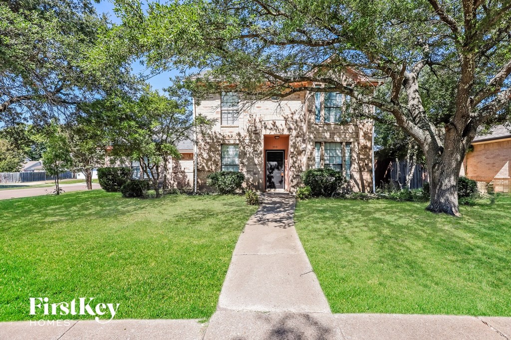 A large house with a tree in front of it.