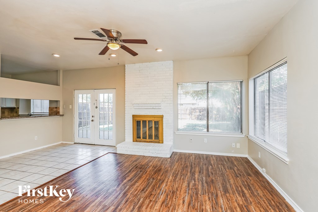 A spacious living room with a fireplace and wood flooring.