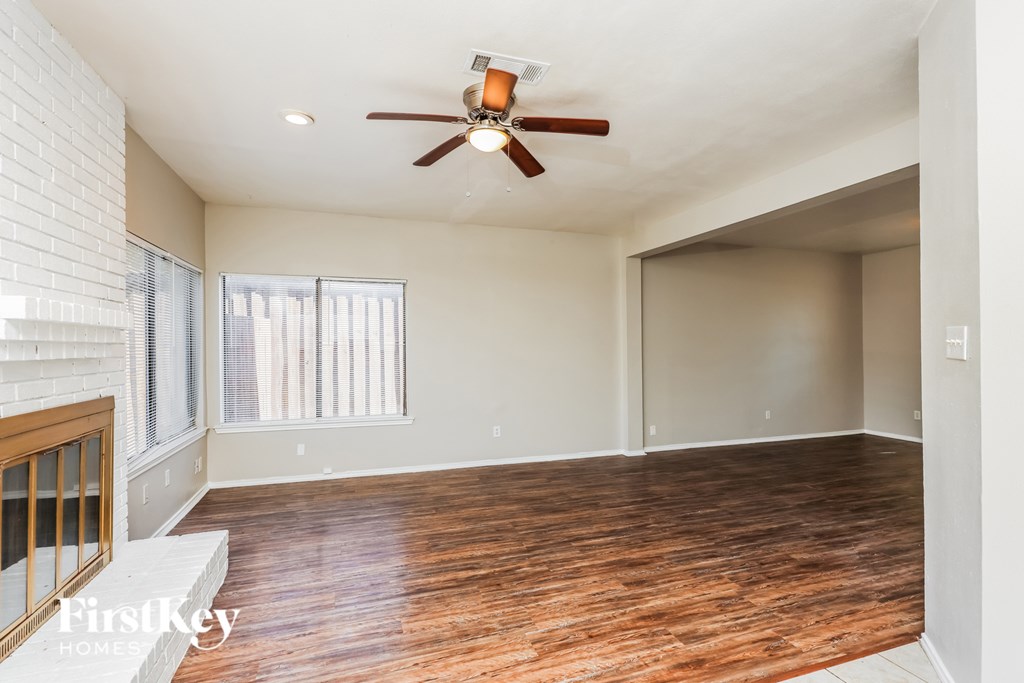 A room with wooden floors and a ceiling fan.