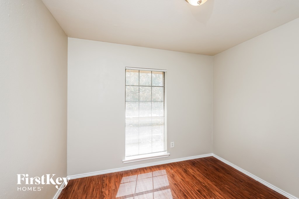 A room with a window and wooden floors.