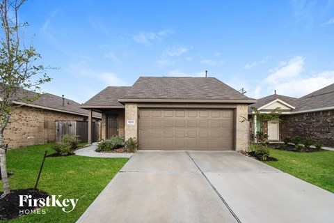 A house with a garage and a driveway in front of it.