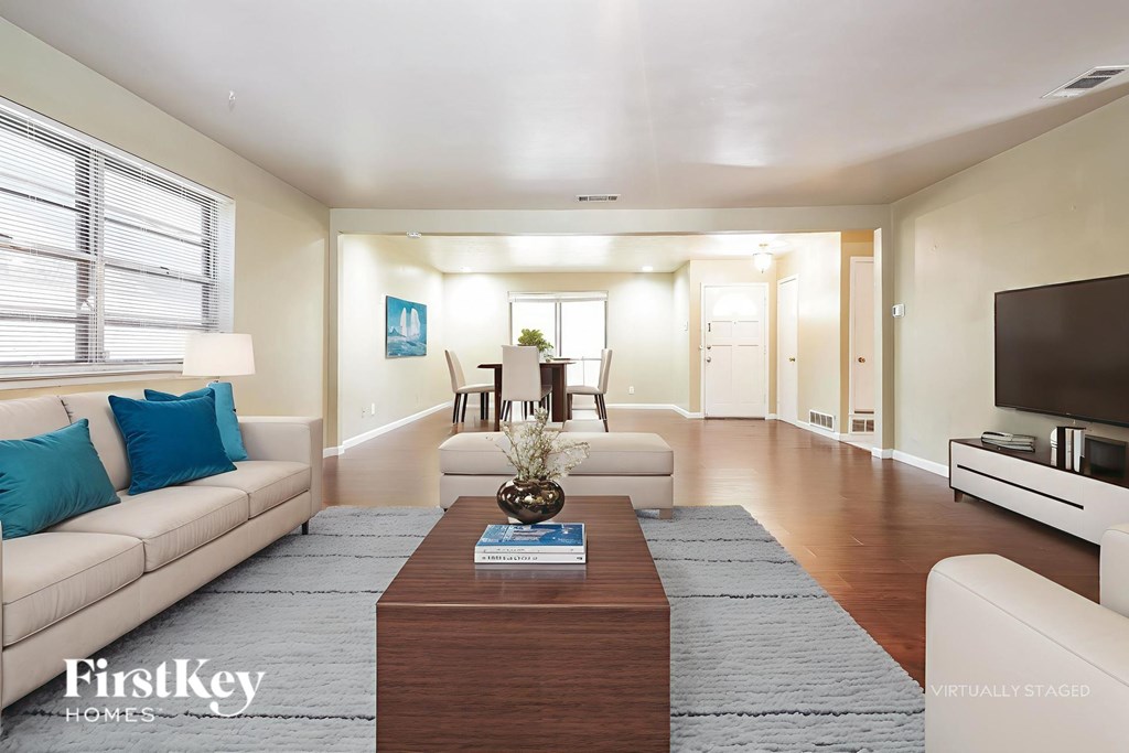 A living room with a white couch and a coffee table.