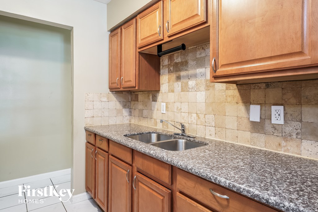 A kitchen with wooden cabinets and granite countertops.