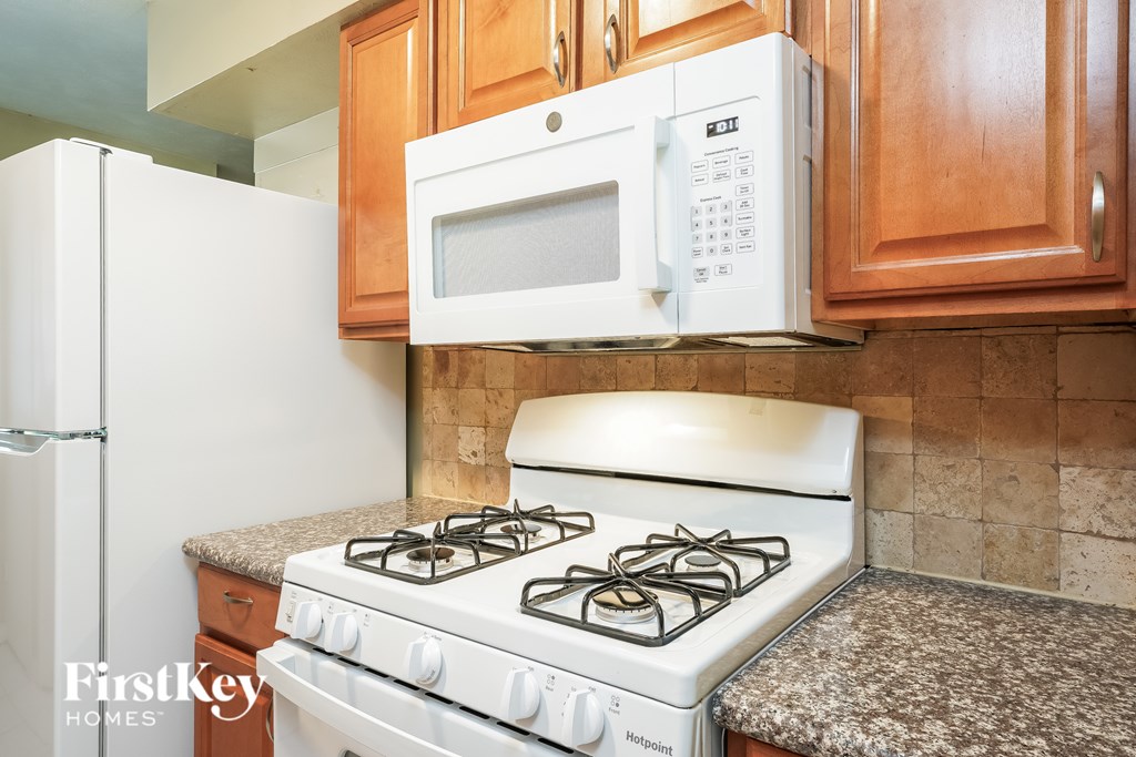 A white stove and microwave in a kitchen.