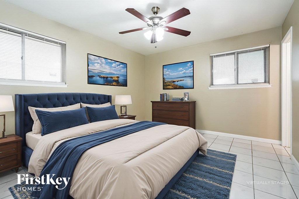 A bedroom with a large bed and a ceiling fan.
