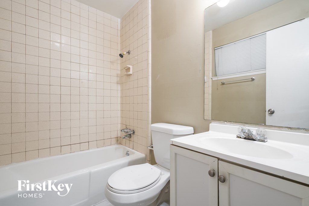 A white toilet sits next to a white sink in a bathroom.