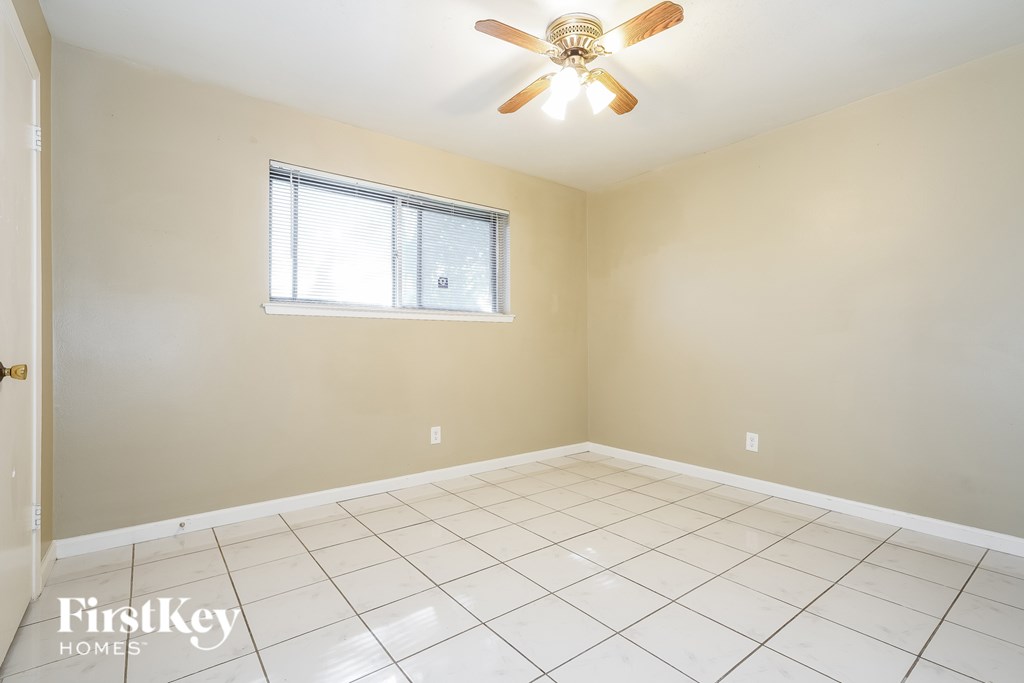 A room with a ceiling fan and a window.