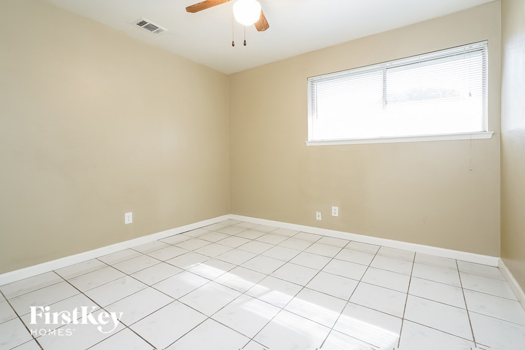 A room with a ceiling fan and a window.