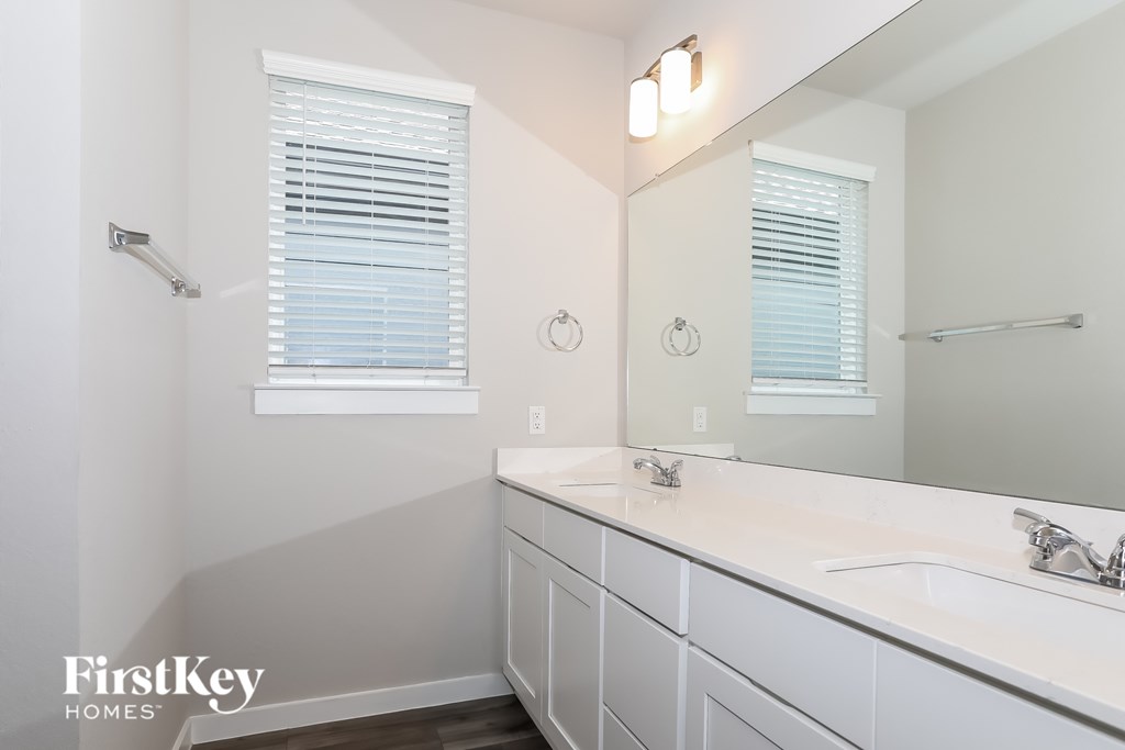 A bathroom with a white sink and a mirror.