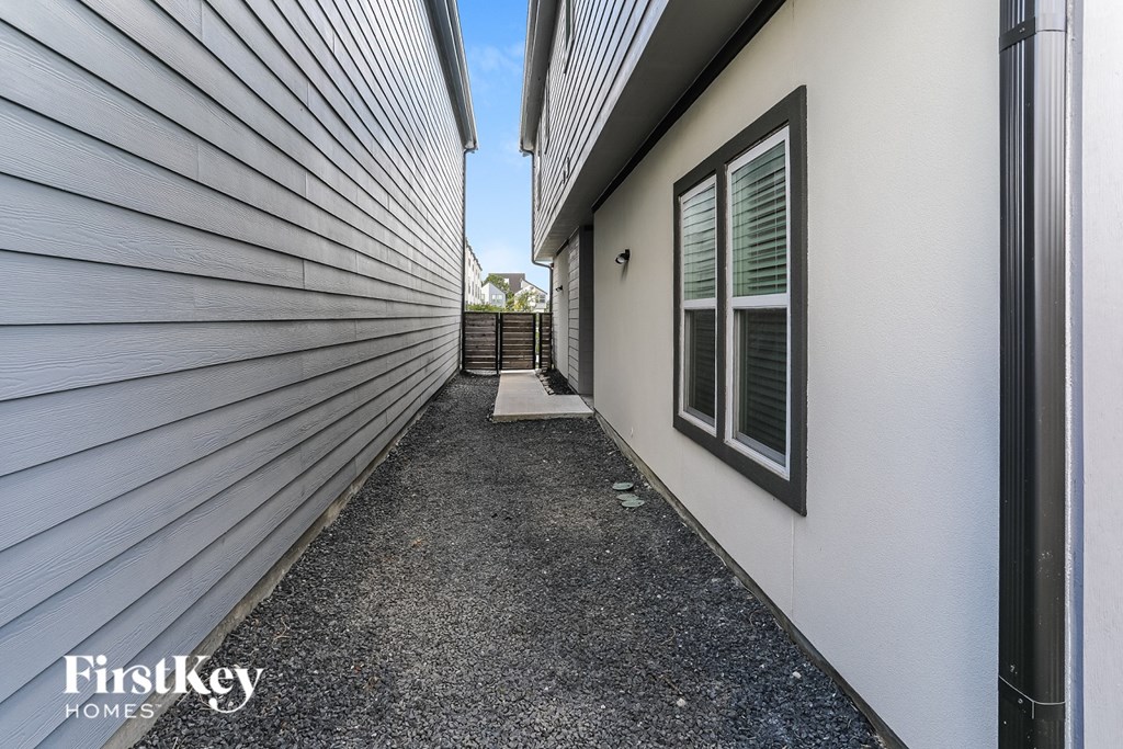 A narrow alley with a FirstKey Homes sign on the wall.