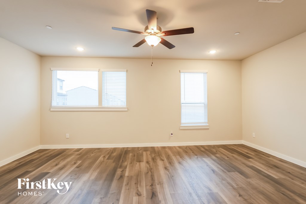 A room with wooden floors and a ceiling fan.