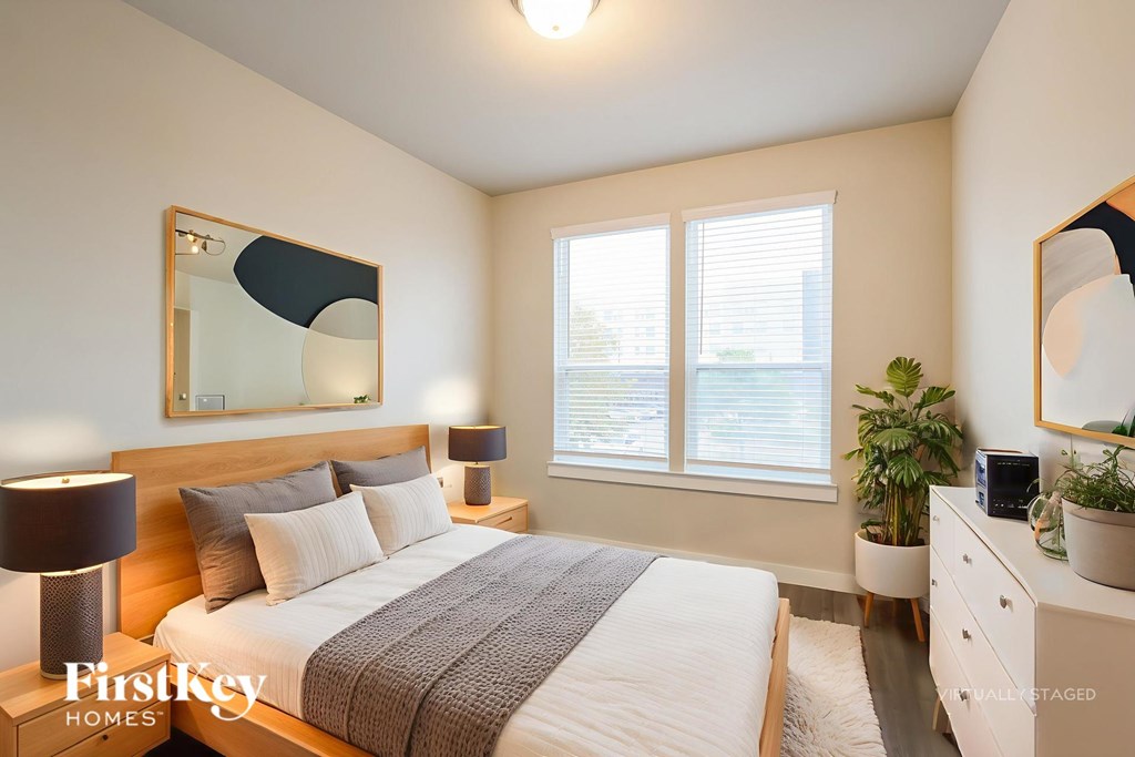 A bedroom with a bed, nightstands, and a mirror.