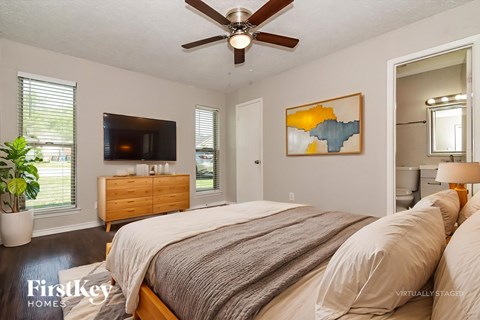 A bedroom with a bed, dresser, and a painting on the wall.