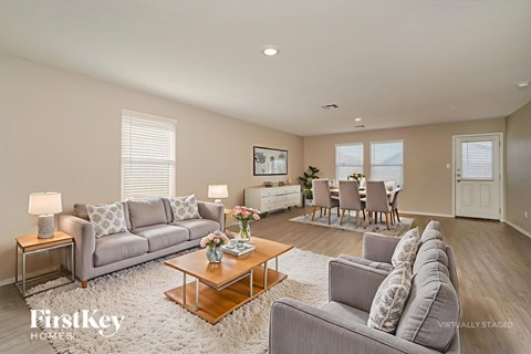 A living room with a grey couch, a coffee table, and a painting on the wall.