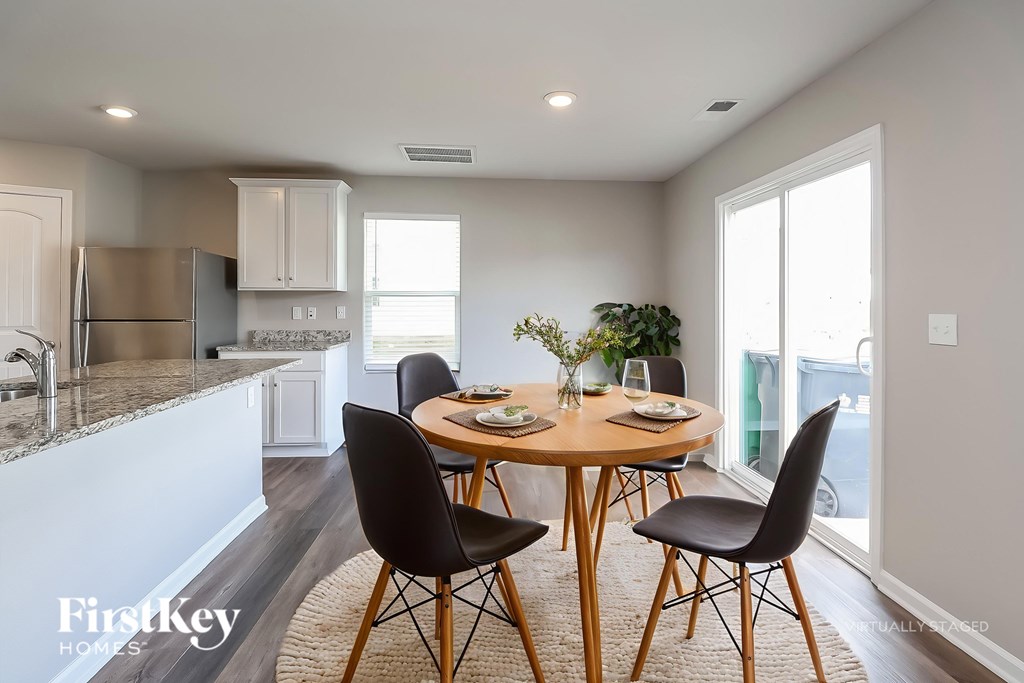 A dining room with a round table and chairs.