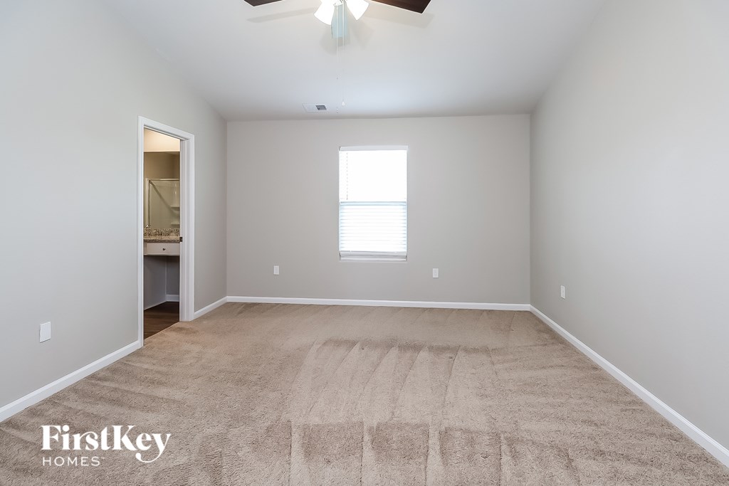 A room with a carpeted floor and a window.