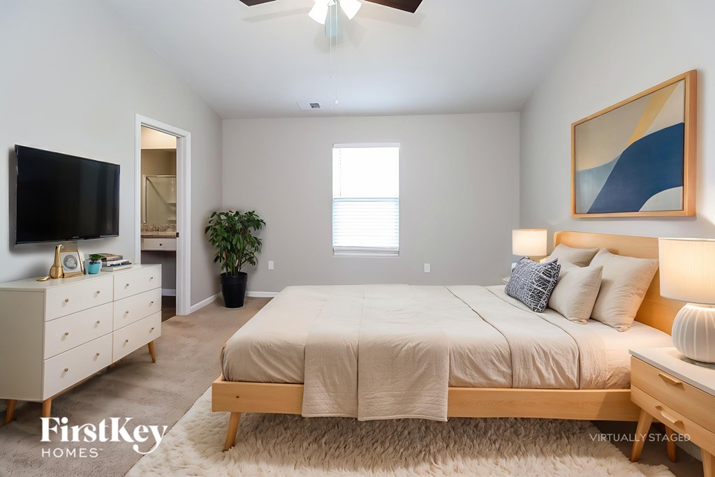 A bedroom with a bed, dresser, and ceiling fan.