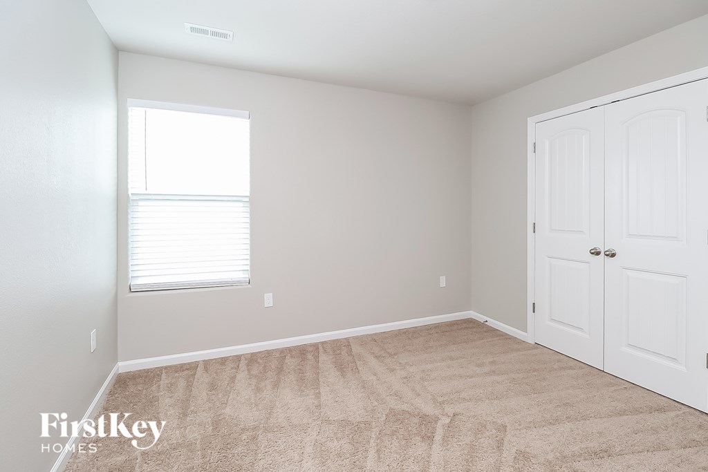 A room with a carpeted floor and a white door.