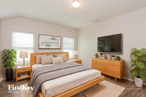 A bedroom with a bed, nightstands, and a television.